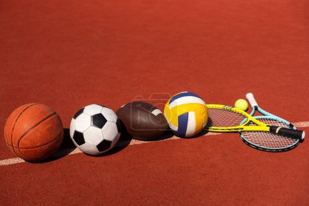 Set of sport equipment, soccer basketball balls and tennis rackets.
