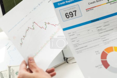 Photo for Cropped view of man holding paper with credit report letters near laptop with blank screen . High quality photo - Royalty Free Image