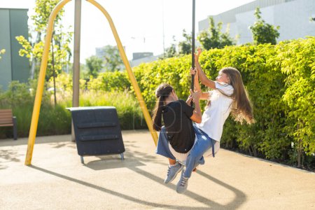 Photo for Girl playing on a swing in the park. High quality photo - Royalty Free Image