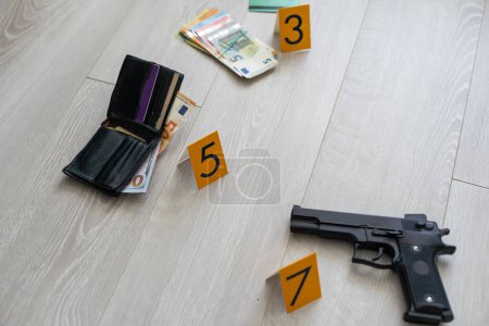 Photo for Crime scene investigation - numbering of evidences after the murdering in apartment. Brass knuckle, wallet and clothes with evidence markers. High quality photo - Royalty Free Image