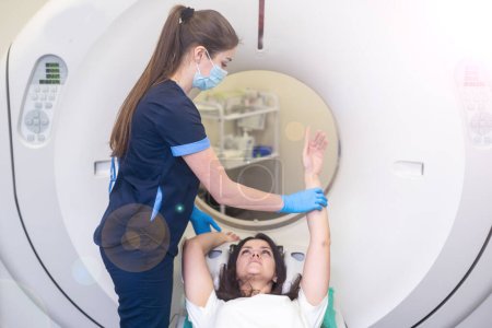 Une femme est allongée sur la table du tomographe. femme subit un examen de tomodensitométrie axiale dans un hôpital moderne.