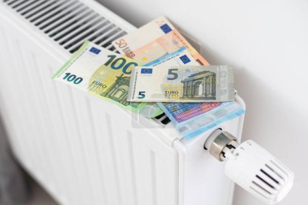 billet de banque couché sur le radiateur, le concept de hausse des prix de l'énergie et de chauffage plus cher. Photo de haute qualité