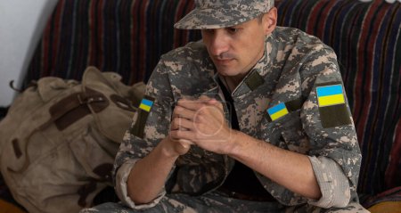 Upset military man sitting at home in thoughts