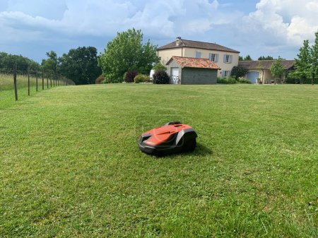 Photo for Robotic lawn mower on grass, side view. High quality photo - Royalty Free Image