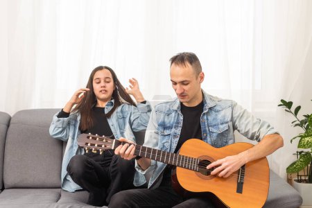 Photo for Smiling father showing daughter how to play barre chord. High quality photo - Royalty Free Image