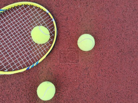  yellow tennis balls and two racquet on hard tennis court surface, top view tennis scene. High quality photo