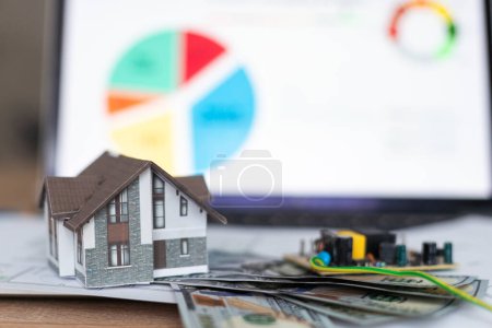 Foto de Una casa modelo encima del montón de dinero sugiriendo ahorros para una casa. Foto de alta calidad - Imagen libre de derechos