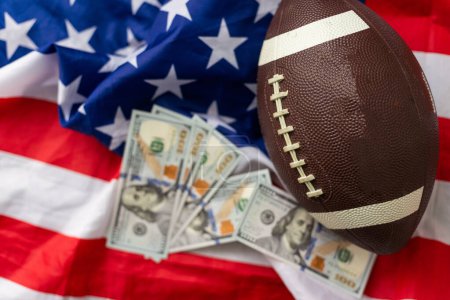 Money and rugby ball on american flag background, closeup. Concept of sports bet. High quality photo