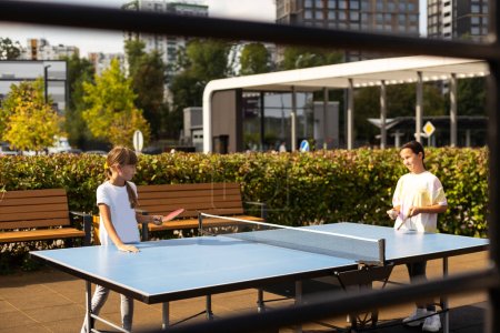Photography of table tennis area in the public park. Street ping-pong sports competitions in spring day. Lifestyles of big city. People playing taBle tennis actively. High quality photo