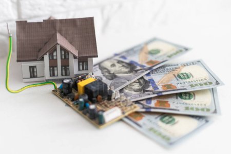 Photo for Model house on top of money pile suggesting savings for a house. High quality photo - Royalty Free Image