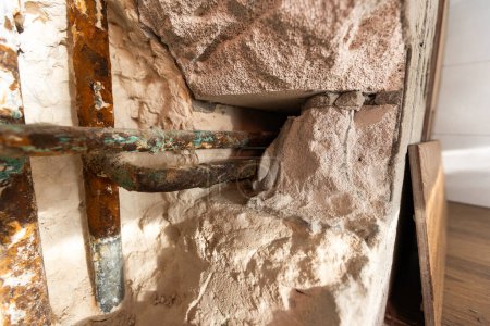 Problem mieszkaniowy, uszkodzenie instalacji wodociągowej w toalecie, wyciek wody na dziurę w ścianie. Wysokiej jakości zdjęcie