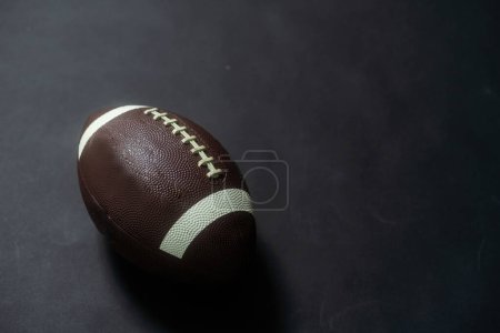 Foto de Fútbol americano en un plano de estudio. La bola está sobre un fondo negro que está ligeramente iluminado. Foto de alta calidad - Imagen libre de derechos