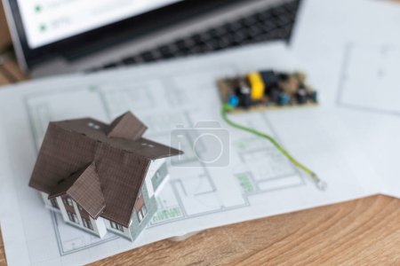 Modelo de casa frente a la computadora con plan de financiamiento - hipoteca o concepto de financiamiento para el hogar. Foto de alta calidad