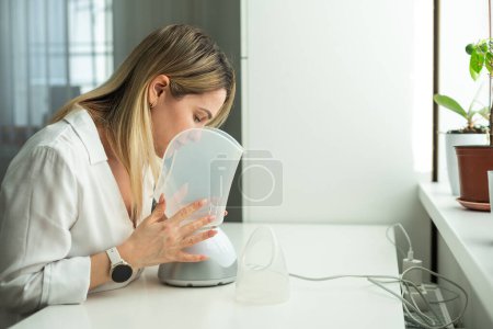 Woman has a bad cold and is trying therapy by inhaler. High quality photo