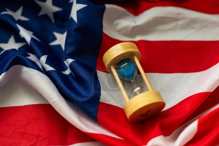 Hourglass and USA flag, soft focus, copy space. High quality photo