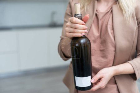 La bouteille est entre les mains d'une femme. Photo de haute qualité