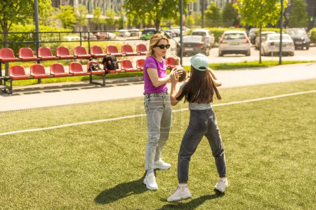 Photo for Mother and daughter playing american football. - Royalty Free Image