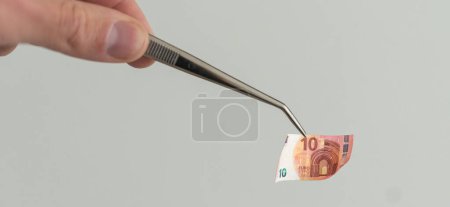 banknote euros money and tweezers