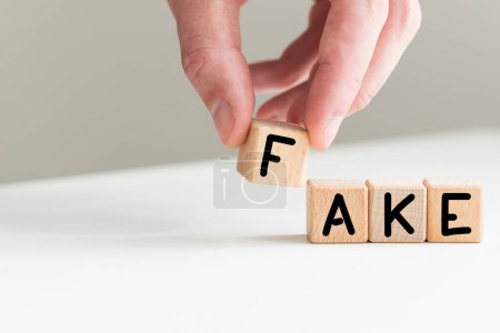 Concept for fake news. Cubes placed on a newspaper form the word FAKE. High quality photo