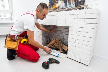 Service technician repairing a fireplace in a home. High quality photo