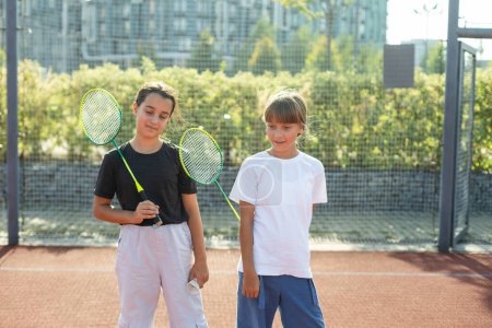 Zwei Mädchen mit Badmintonschlägern auf dem Fußballplatz. Hochwertiges Foto