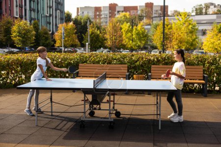 Fotografie des Tischtennisplatzes im öffentlichen Park. Street-Ping-Pong-Sportwettkämpfe im Frühling. Lebensstil der Großstadt. Menschen, die aktiv TaBle-Tennis spielen. Hochwertiges Foto