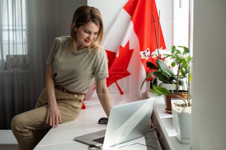 Foto de Las manos de la mujer y la bandera de Canadá en el ordenador, teclado portátil. Foto de alta calidad - Imagen libre de derechos