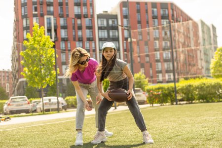 mère et fille jouant au football américain.