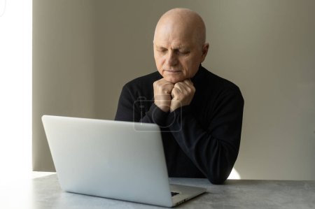 Close up of modern elderly man sit at home having online consultation with doctor on computer, sick senior male talk on video call consulting with female nurse using laptop, healthcare concept