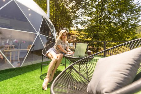 Frau arbeitet am Laptop Outdoor Bubble Tent House Dome - Nature travel Concept