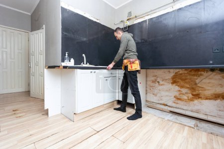 Älterer Mann demontiert Wohnküche außer Betrieb. Hochwertiges Foto