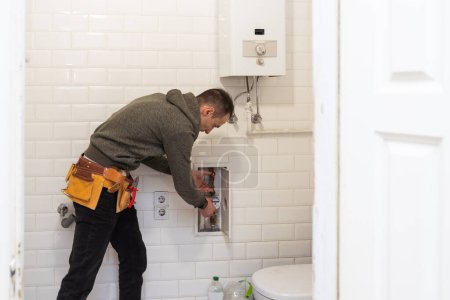 Reparaturhelfer installieren Toilettenspülung, Toilettenschüssel im Badezimmer. Hochwertiges Foto