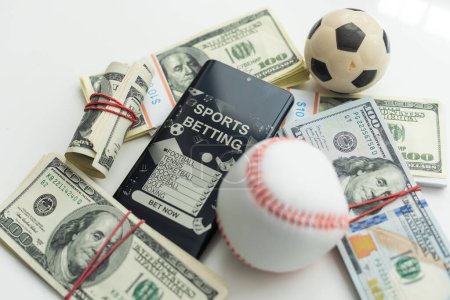 Foto de Smartphone con aplicación móvil de juegos de azar y pelota de fútbol con el dinero de cerca. Concepto de deporte y apuestas. Foto de alta calidad - Imagen libre de derechos