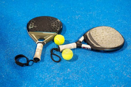  rackets paddle with two balls on blue background. High quality photo
