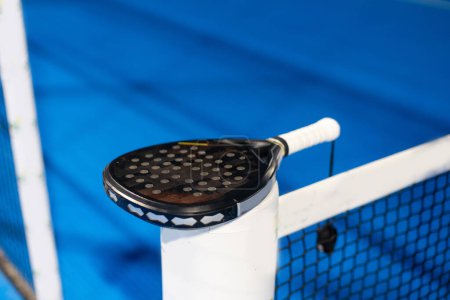 Paddle tennis: Paddel racket and ball in front of an outdoor court. High quality photo