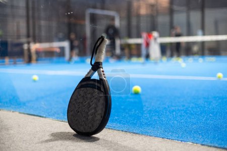 Paddle tennis: Paddel racket and ball in front of an outdoor court. High quality photo