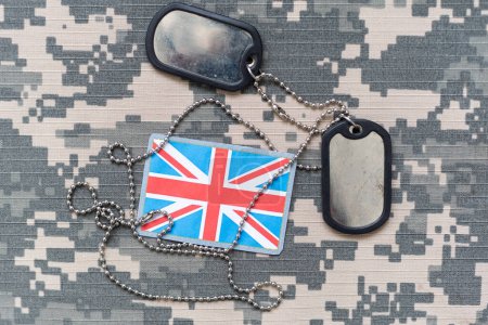 army blank, dog tag with flag of great britain on the khaki texture background. military concept. High quality photo