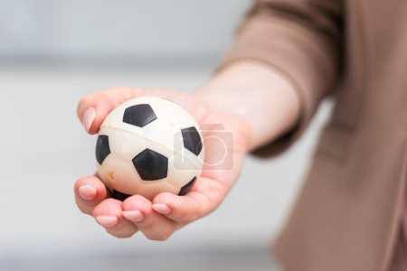 Frauenhand mit Fußball auf weißem Hintergrund. Hochwertiges Foto