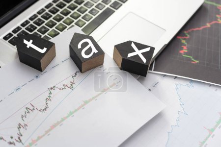 Tax text in wooden cubes and tax or vat form documents to complete Individual income tax return form for payment to Government. Calculation tax return in 2022 to 2023. High quality photo