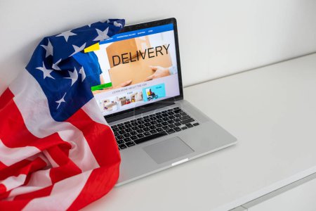 Amerikanische Flagge. Laptop und amerikanische Flagge, Einkaufen. Hochwertiges Foto