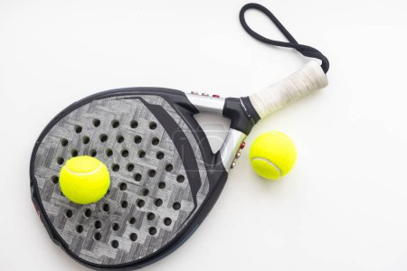 Set of paddle tennis rackets and balls the reflected on white table and white isolated background. Front view. High quality photo