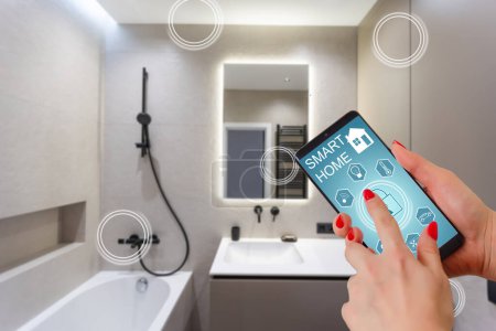 Foto de Las manos femeninas sosteniendo el teléfono con la pantalla de inicio inteligente aplicación en la casa habitación
. - Imagen libre de derechos