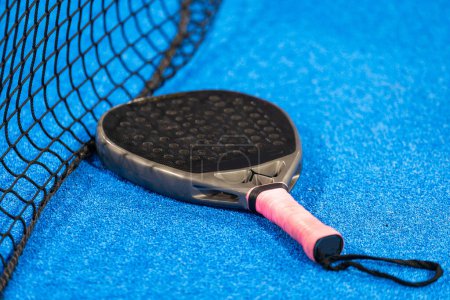 paddle tennis racket and balls on the blue paddle court. High quality photo