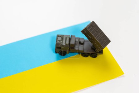 Sistema de cohetes de artillería están dirigidos al cielo y soldado al atardecer con bandera ucraniana. Sistema de lanzamiento múltiple de cohetes. Foto de alta calidad