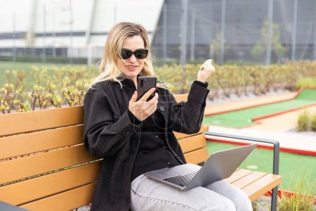 Eine Geschäftsfrau mit einem Laptop auf einem Golfplatz. Hochwertiges Foto