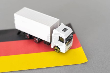 Mini juguete en la mesa con fondo borroso. Concepto de envío industrial. Camión de juguete, bandera de Alemania. Foto de alta calidad