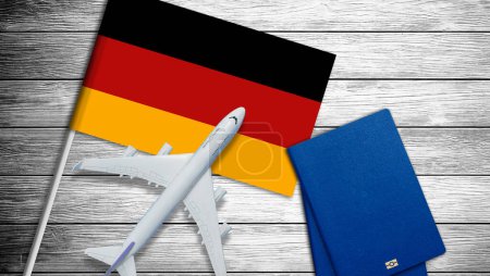 Deutschland-Fahne mit Pass und Spielzeugflugzeug. Flugreisekonzept. Hochwertiges Foto
