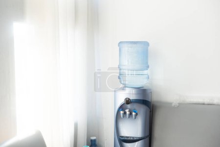 Blue water gallon on water cooler in office