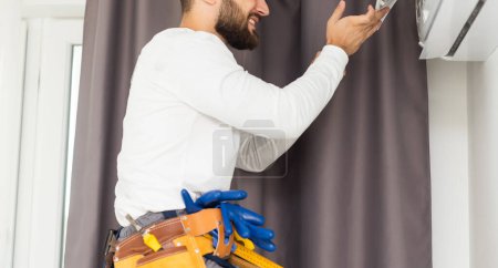 Téléchargez les photos : Technicien masculin réparant climatiseur intérieur
. - en image libre de droit