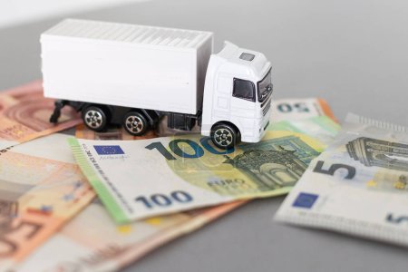 Téléchargez les photos : Camion jouet blanc sur les billets en euros. concept pour la logistique, le transport et la finance. Photo de haute qualité - en image libre de droit